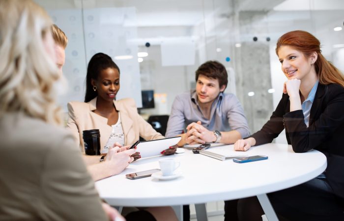Group of business people sitting at desk and discussing new ideas